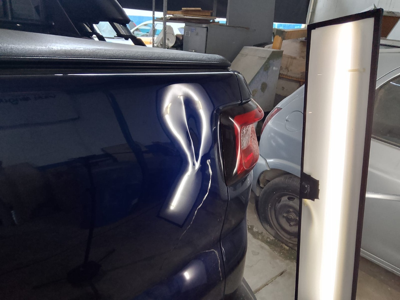 Amassado em lataria escura com luz técnica